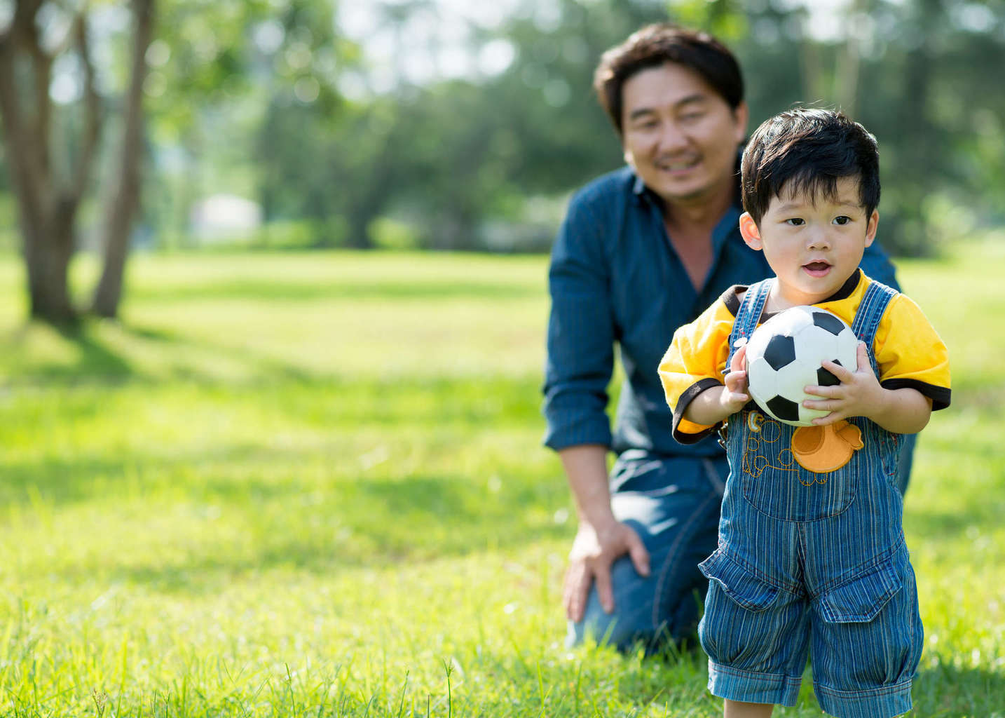 ayah anak laki-laki bermain bola